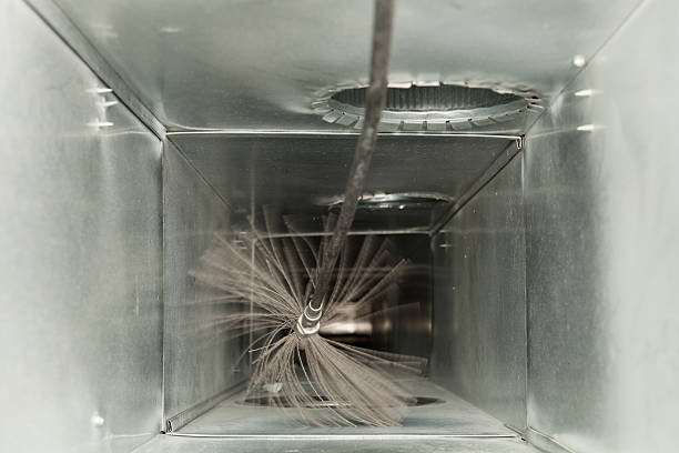 Inside a metal duct, a cleaning brush spins, removing dust and debris from the vent.